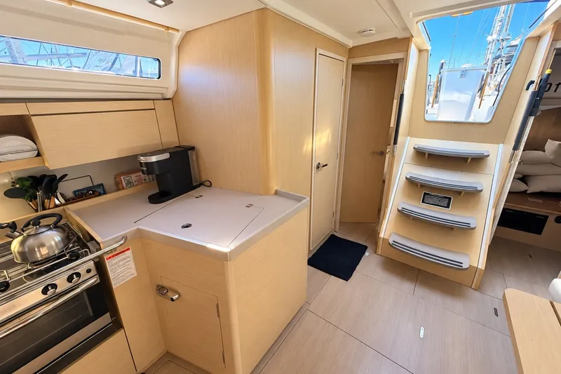 Slide: The Image of Modern interior of 2022 Beneteau Oceanis 40.1 yacht, featuring a compact kitchen and sleek design. - 10