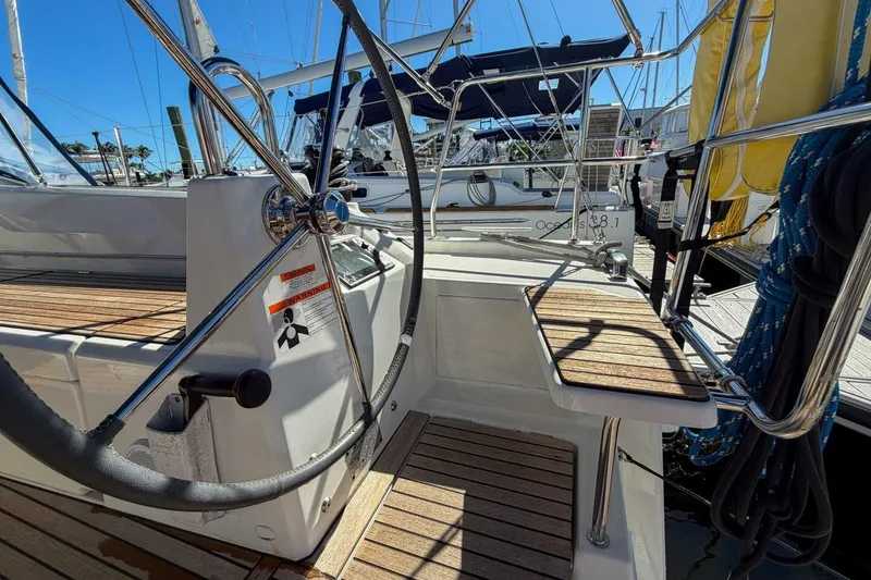 Slide: The Image of 2022 Beneteau Oceanis 40.1 sailboat cockpit with steering wheel and wooden deck. - 62