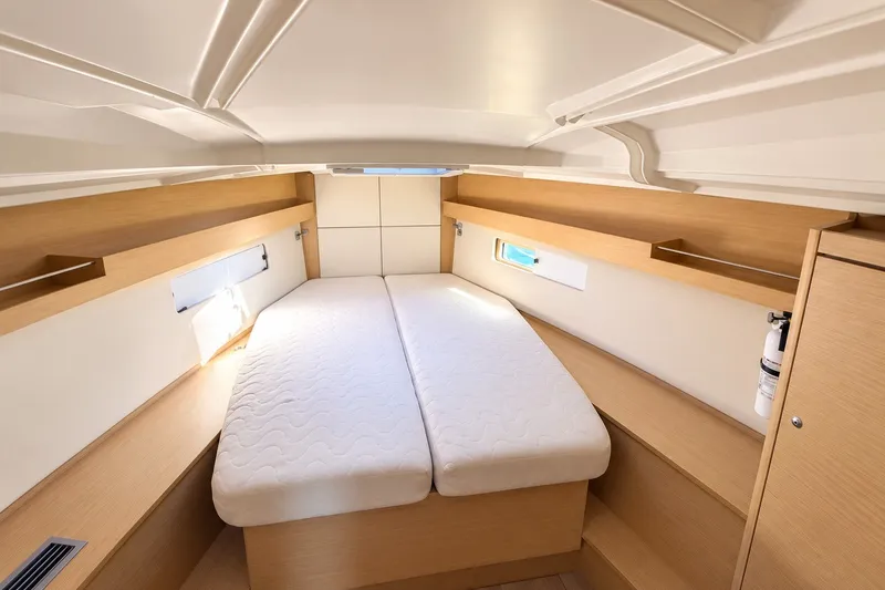 Slide: The Image of Interior cabin of 2022 Beneteau Oceanis 40.1 yacht, featuring a cozy bed and wooden shelves. - 29