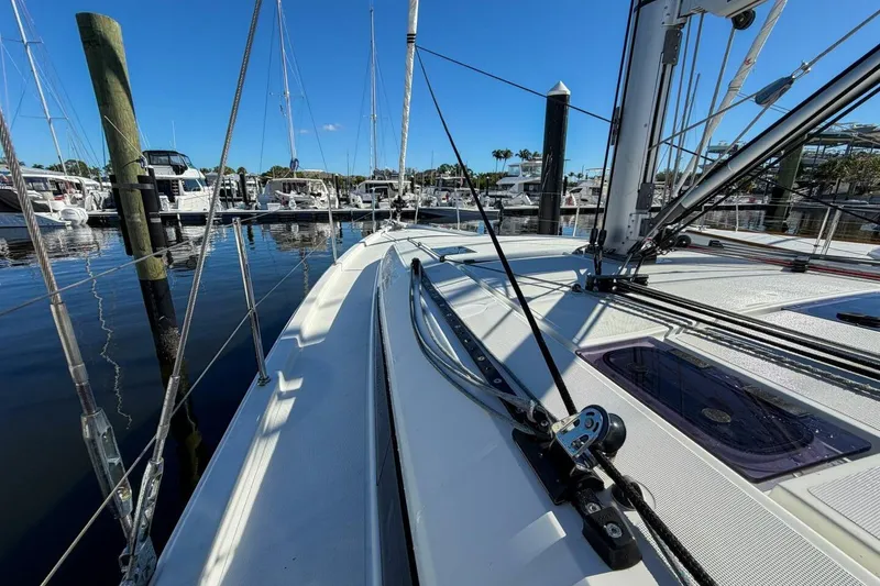 Slide: The Image of 2022 Beneteau Oceanis 40.1 sailboat docked in a marina under clear blue skies. - 94