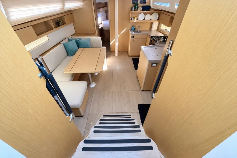 Slide: The Image of Interior of 2022 Beneteau Oceanis 40.1 yacht, featuring modern kitchen and cozy seating area. - 2
