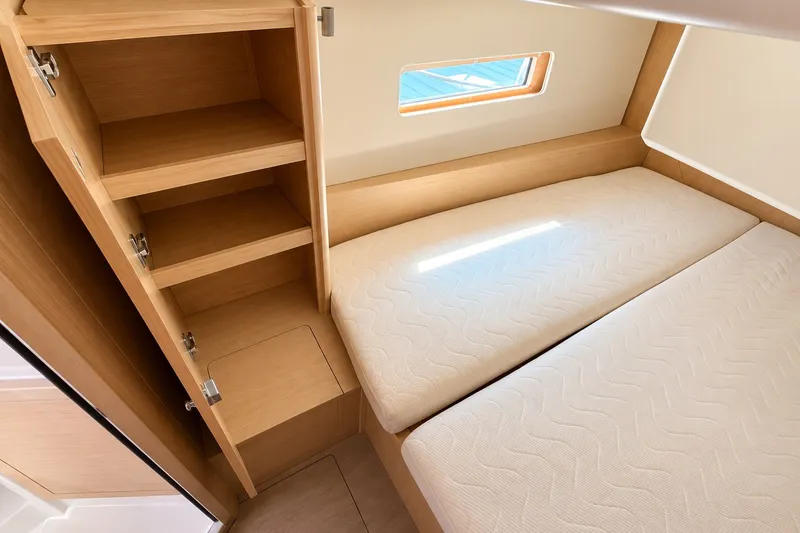 Slide: The Image of Interior cabin of 2022 Beneteau Oceanis 40.1 with twin beds and wooden storage shelves. - 28
