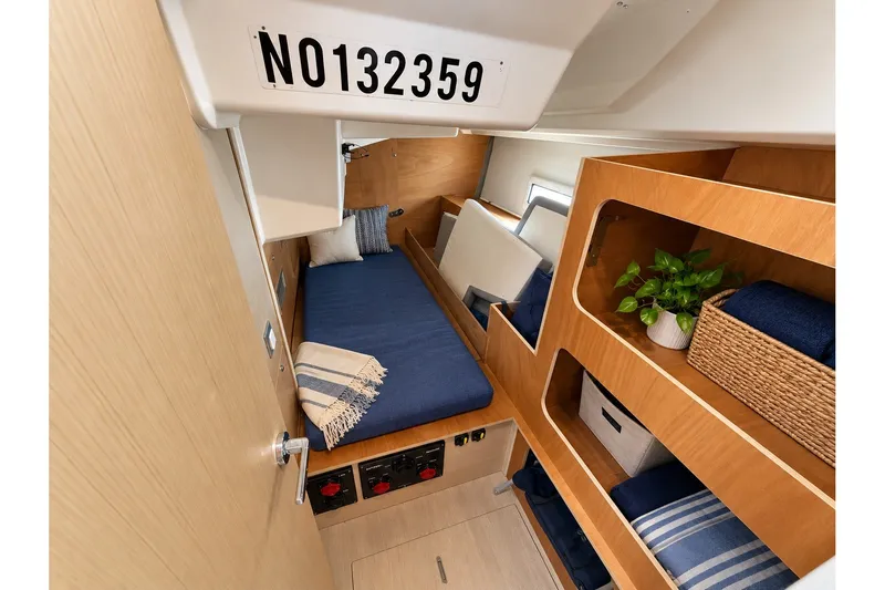 Slide: The Image of Cozy cabin interior of 2022 Beneteau Oceanis 40.1 with wooden shelves and blue bedding. - 31