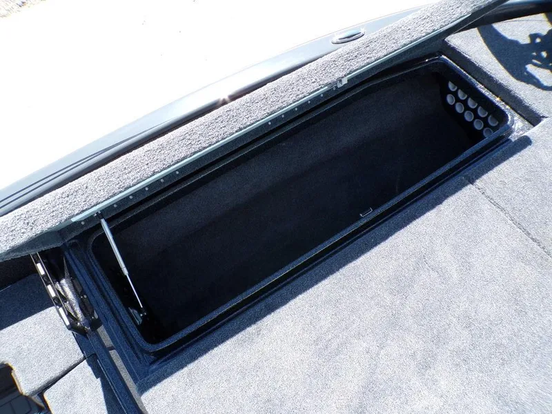 Slide: The Image of Open storage compartment in 2025 Phoenix 920 Elite boat, featuring carpeted interior. - 17