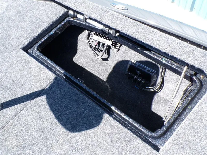 Slide: The Image of Open storage compartment in 2025 Phoenix 920 Elite boat, showcasing wiring and equipment. - 18