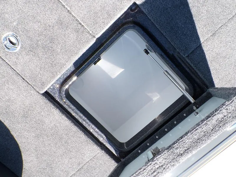 Slide: The Image of Open storage compartment on 2025 Phoenix 920 Elite boat, featuring carpeted interior. - 27