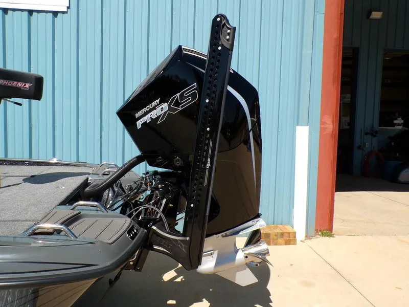 Slide: The Image of Phoenix 920 Elite 2025 boat with Mercury Pro XS engine, docked near a blue building. - 6