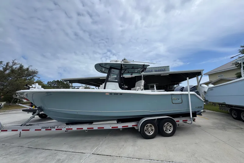 The Image of 2020 Sea Hunt Gamefish 30 boat on trailer, parked outdoors under cloudy sky. - 1