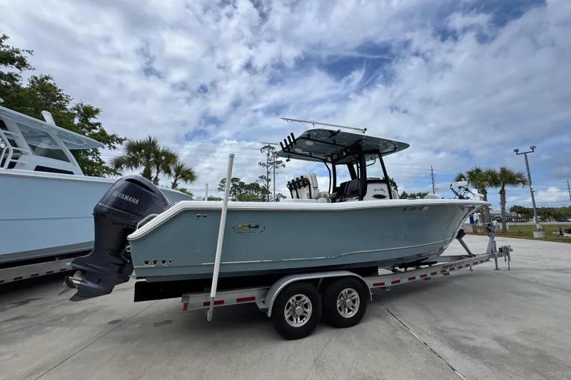 Slide: The Image of 2020 Sea Hunt Gamefish 30 boat on trailer, featuring Yamaha outboard motor, under cloudy sky. - 10