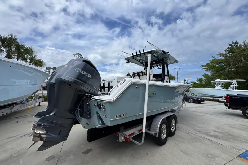 Slide: The Image of 2020 Sea Hunt Gamefish 30 boat with Yamaha engine on trailer, under cloudy sky. - 11