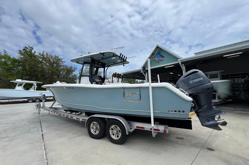 Slide: The Image of 2020 Sea Hunt Gamefish 30 boat on trailer, parked outdoors near a boatyard. - 15