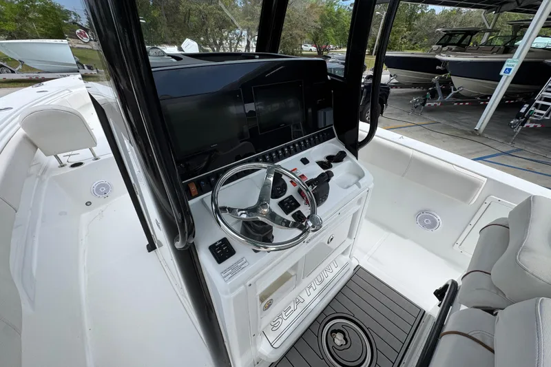 Slide: The Image of 2020 Sea Hunt Gamefish 30 boat cockpit with steering wheel and control panel. - 29