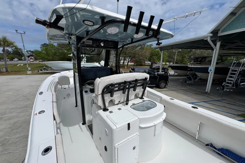 Slide: The Image of 2020 Sea Hunt Gamefish 30 Forward Seating boat at a marina, showcasing fishing rod holders. - 34