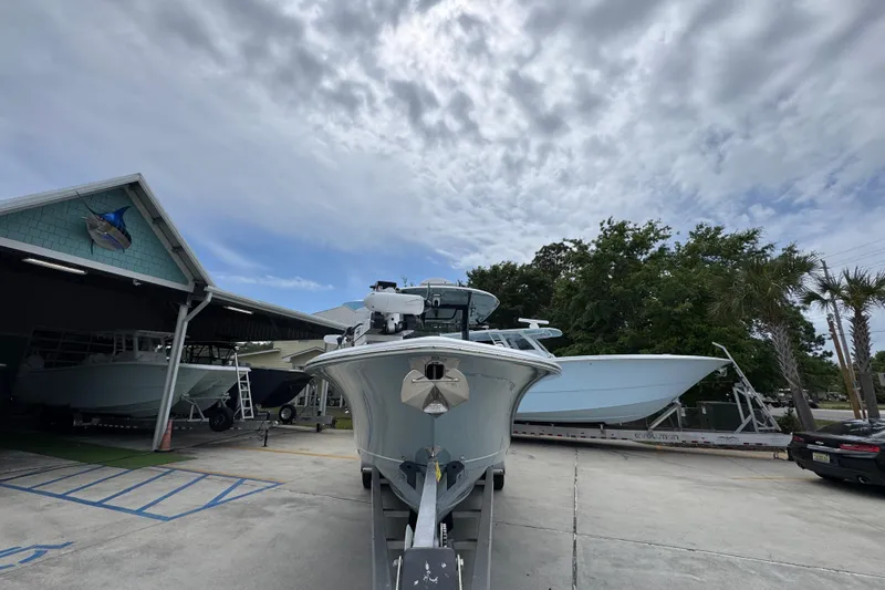 Slide: The Image of 2020 Sea Hunt Gamefish 30 Forward Seating boat on trailer under cloudy sky. - 6