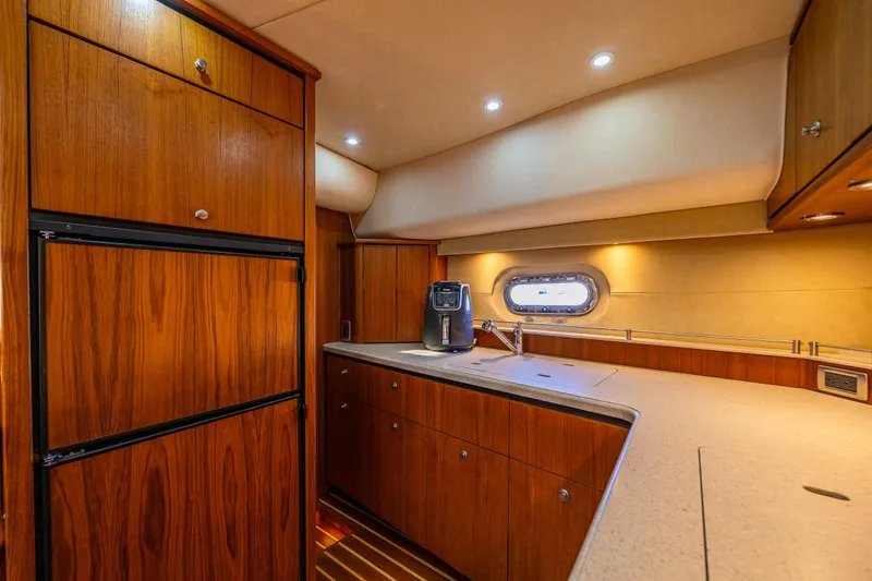 Slide: The Image of Luxurious 2006 Tiara Yachts 4000 Sovran kitchen with wood cabinetry and modern appliances. - 48