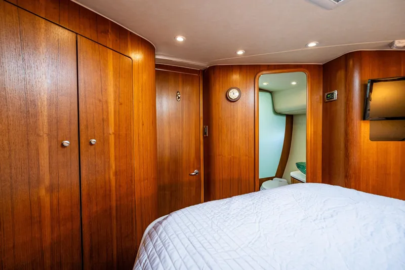 Slide: The Image of Primary stateroom 2006 Tiara Yachts 4000 Sovran cabin interior with wood paneling and cozy bedding. - 50