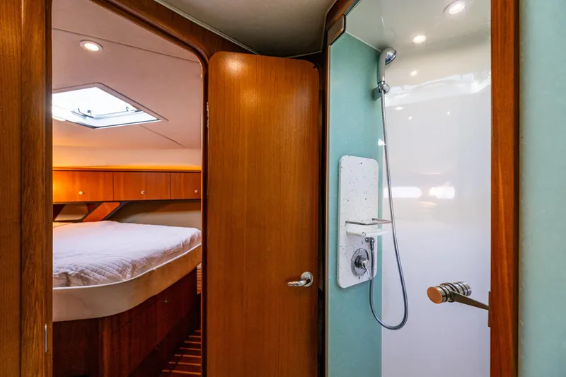 Slide: The Image of Interior of 2006 Tiara Yachts 4000 Sovran, featuring a cozy bedroom with head and shower. - 54