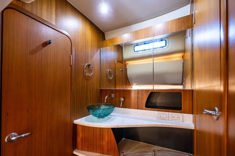 Slide: The Image of Luxurious 2006 Tiara Yachts 4000 Sovran bathroom with wooden cabinetry and modern glass sink. - 57