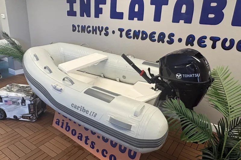 Slide: The Image of Inflatable Caribe L-8 boat with Tohatsu motor, displayed indoors, 2026 model. - 3