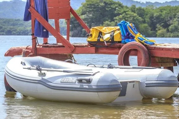 Slide: The Image of Inflatable Caribe L-8 boat docked by a wooden pier, surrounded by scenic nature, 2025 model. - 5