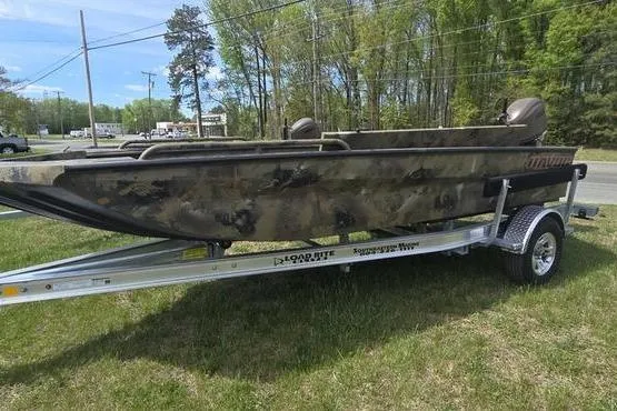 The Image of 2026 Havoc 1760 VJST boat on trailer, camo design, parked on grass. - 0
