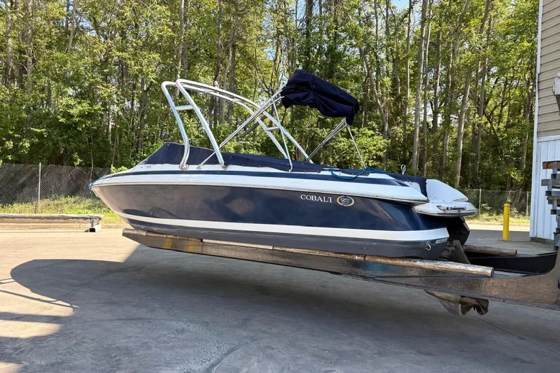The Image of 2002 Cobalt 240 boat on trailer, parked outdoors near trees. - 0