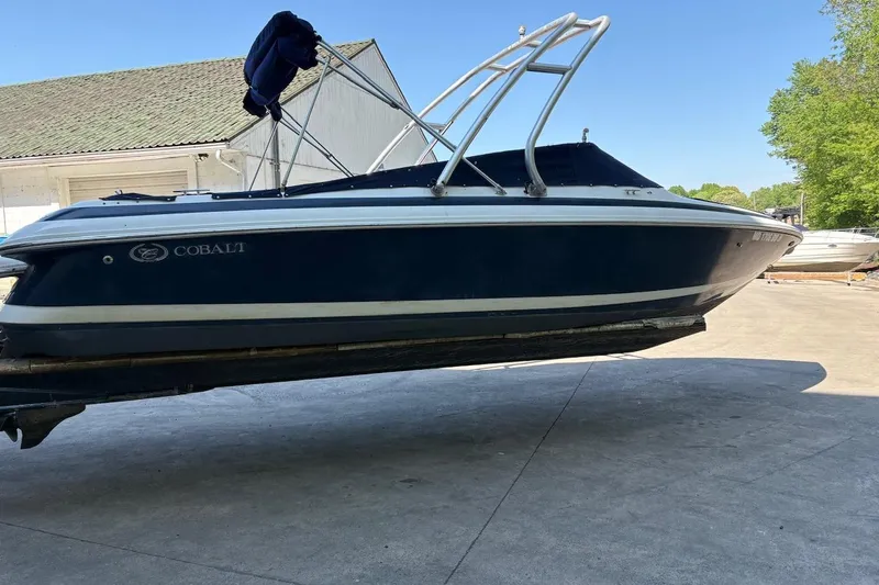 Slide: The Image of 2002 Cobalt 240 boat on trailer, blue hull, parked outdoors. - 2