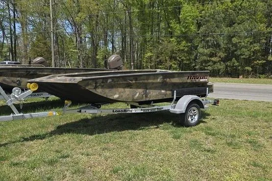 Slide: The Image of 2026 Havoc 1553 VJST boat on trailer, parked on grass, surrounded by trees. - 6