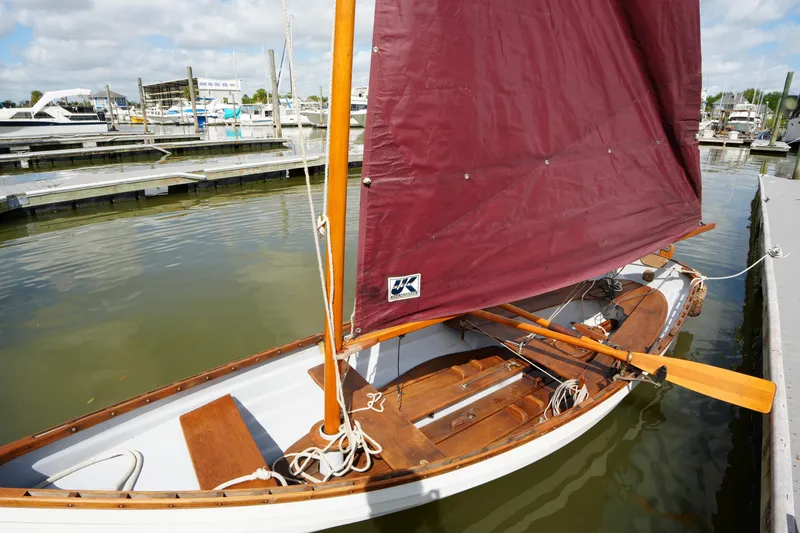 Slide: The Image of Whitehall Spirit 19 sailboat from 2006 docked with maroon sail and wooden interior. - 4