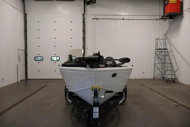 Slide: The Image of 2026 Crestliner 1650 Kodiak SC boat in a spacious indoor garage setting. - 6