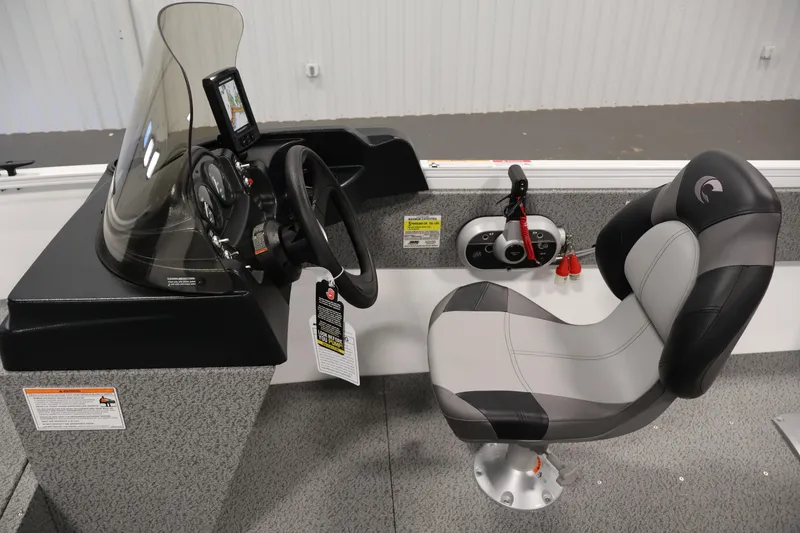 Slide: The Image of 2026 Crestliner 1650 Kodiak SC boat interior with steering console and cushioned seat. - 23