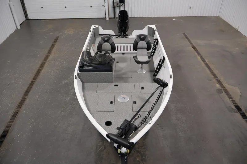 Slide: The Image of 2026 Crestliner 1650 Kodiak SC fishing boat in a garage, featuring dual seats and trolling motor. - 13