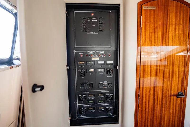 Slide: The Image of Electrical panel inside a 2012 Hatteras 80 Motor Yacht, showcasing control switches and meters. - 101
