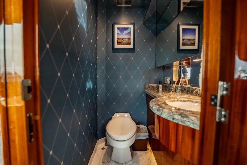 Slide: The Image of Luxurious bathroom on 2012 Hatteras 80 Motor Yacht with elegant blue wallpaper and marble countertop. - 103