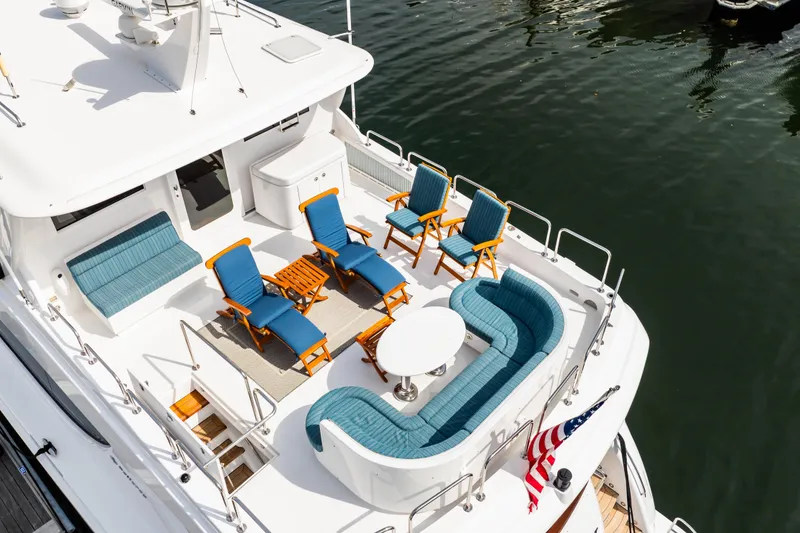 Slide: The Image of Luxurious 2012 Hatteras 80 Motor Yacht deck with seating and American flag. - 11
