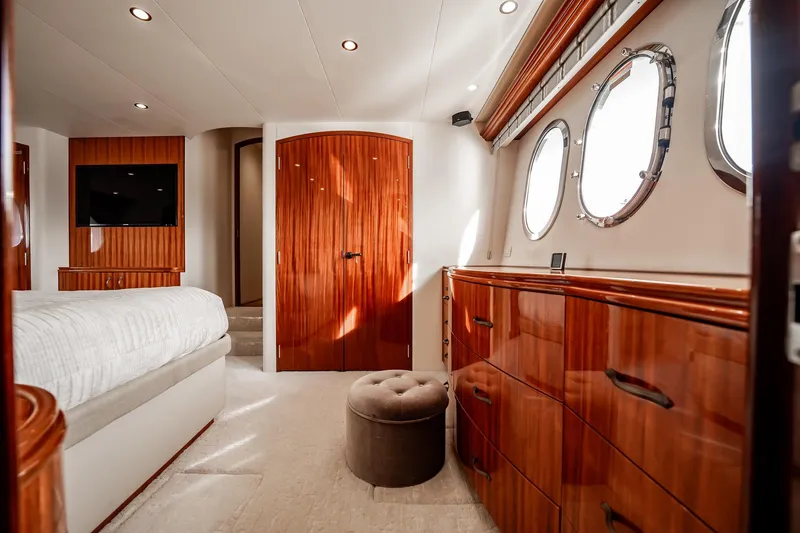 Slide: The Image of Luxurious 2012 Hatteras 80 Motor Yacht bedroom with elegant wood finishes and porthole windows. - 114