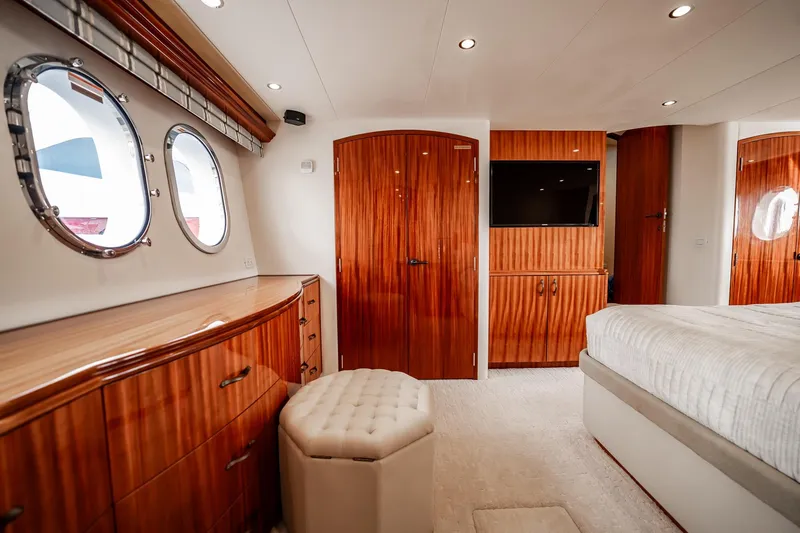 Slide: The Image of Luxurious 2012 Hatteras 80 Motor Yacht bedroom with elegant wood finishes and porthole windows. - 118