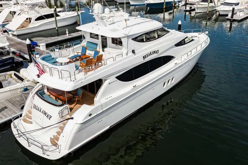Slide: The Image of Luxury 2012 Hatteras 80 Motor Yacht docked, featuring spacious deck and elegant design. - 12