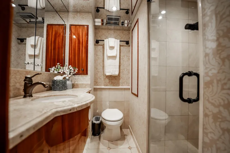 Slide: The Image of Luxurious bathroom on 2012 Hatteras 80 Motor Yacht with elegant fixtures and wood accents. - 124