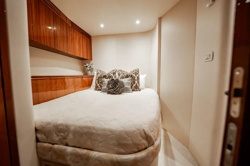 Slide: The Image of Luxurious bedroom interior on 2012 Hatteras 80 Motor Yacht with elegant bedding and wood cabinetry. - 147