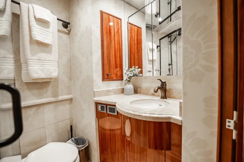 Slide: The Image of Luxurious bathroom interior on 2012 Hatteras 80 Motor Yacht, featuring elegant wood cabinetry and modern fixtures. - 148