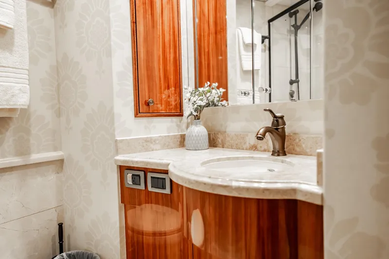 Slide: The Image of Luxurious bathroom on 2012 Hatteras 80 Motor Yacht with elegant wood cabinetry and floral decor. - 149