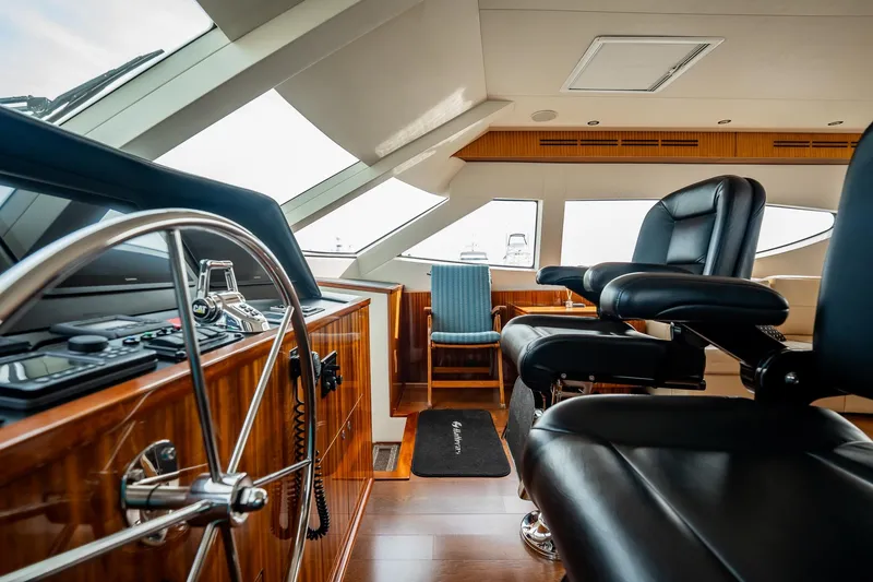 Slide: The Image of Luxurious helm of 2012 Hatteras 80 Motor Yacht with leather seating and wooden accents. - 15