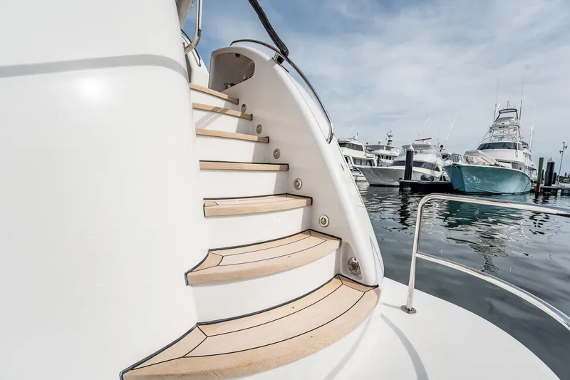 Slide: The Image of Elegant staircase on 2012 Hatteras 80 Motor Yacht, docked at marina with other boats. - 158