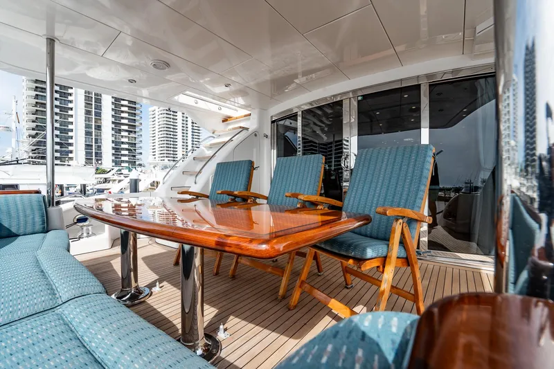 Slide: The Image of Luxurious deck seating on 2012 Hatteras 80 Motor Yacht with polished wood table. - 162