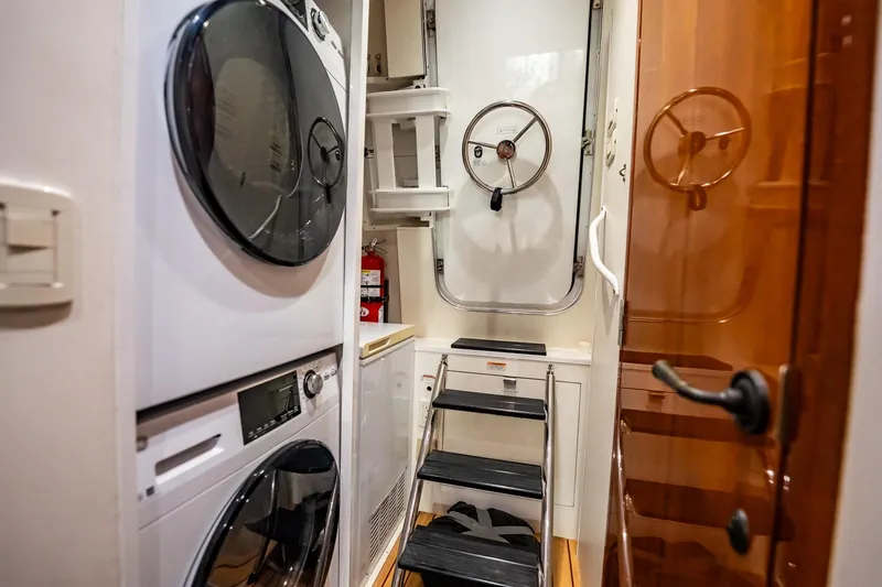 Slide: The Image of Laundry area with stacked washer and dryer on 2012 Hatteras 80 Motor Yacht. - 163