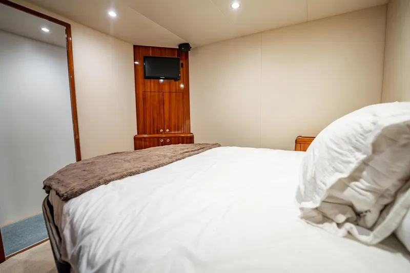 Slide: The Image of Luxurious bedroom interior of 2012 Hatteras 80 Motor Yacht with cozy bedding and wooden accents. - 178