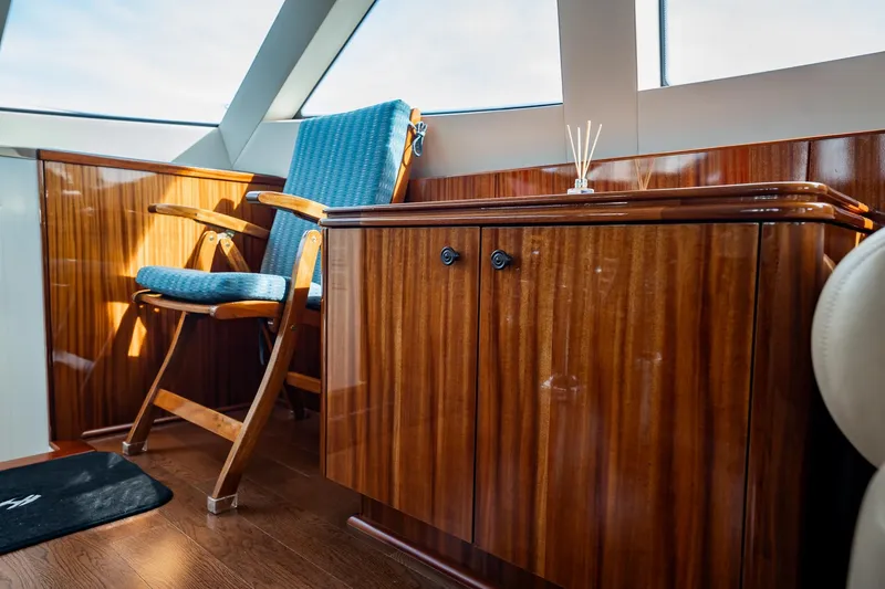 Slide: The Image of Luxurious interior of 2012 Hatteras 80 Motor Yacht with wooden cabinetry and blue chair. - 18