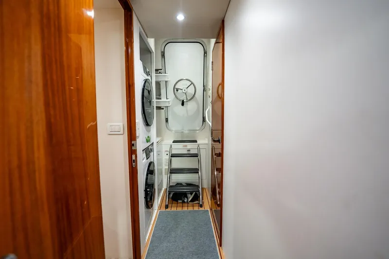 Slide: The Image of Laundry area inside 2012 Hatteras 80 Motor Yacht with stacked washer and dryer. - 180