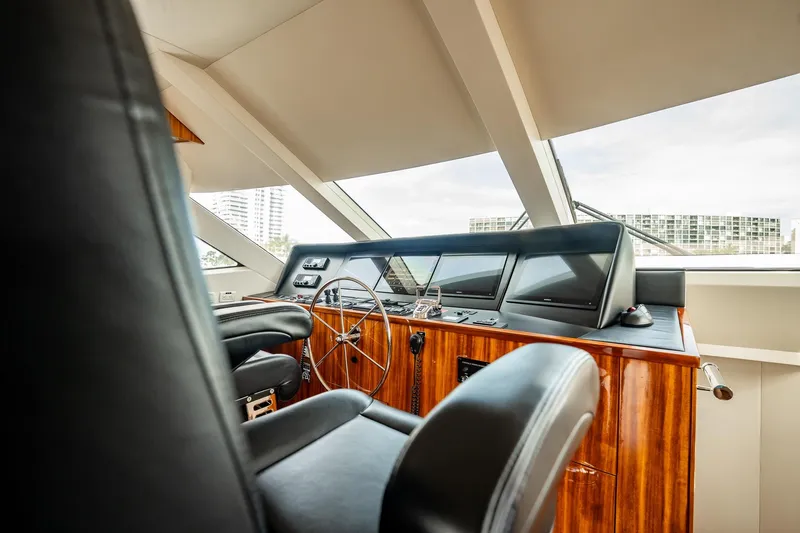 Slide: The Image of Luxurious helm of 2012 Hatteras 80 Motor Yacht with sleek wood finish and modern controls. - 19